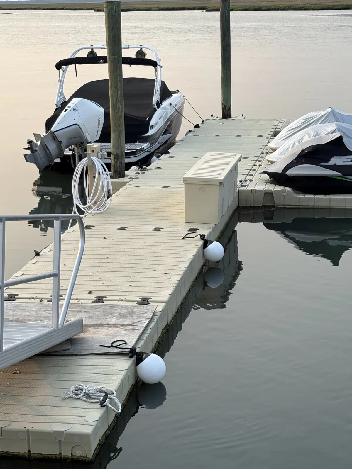 Boat and covered jet ski moored at a calm dock — JetPro Powersport in Atlantic City