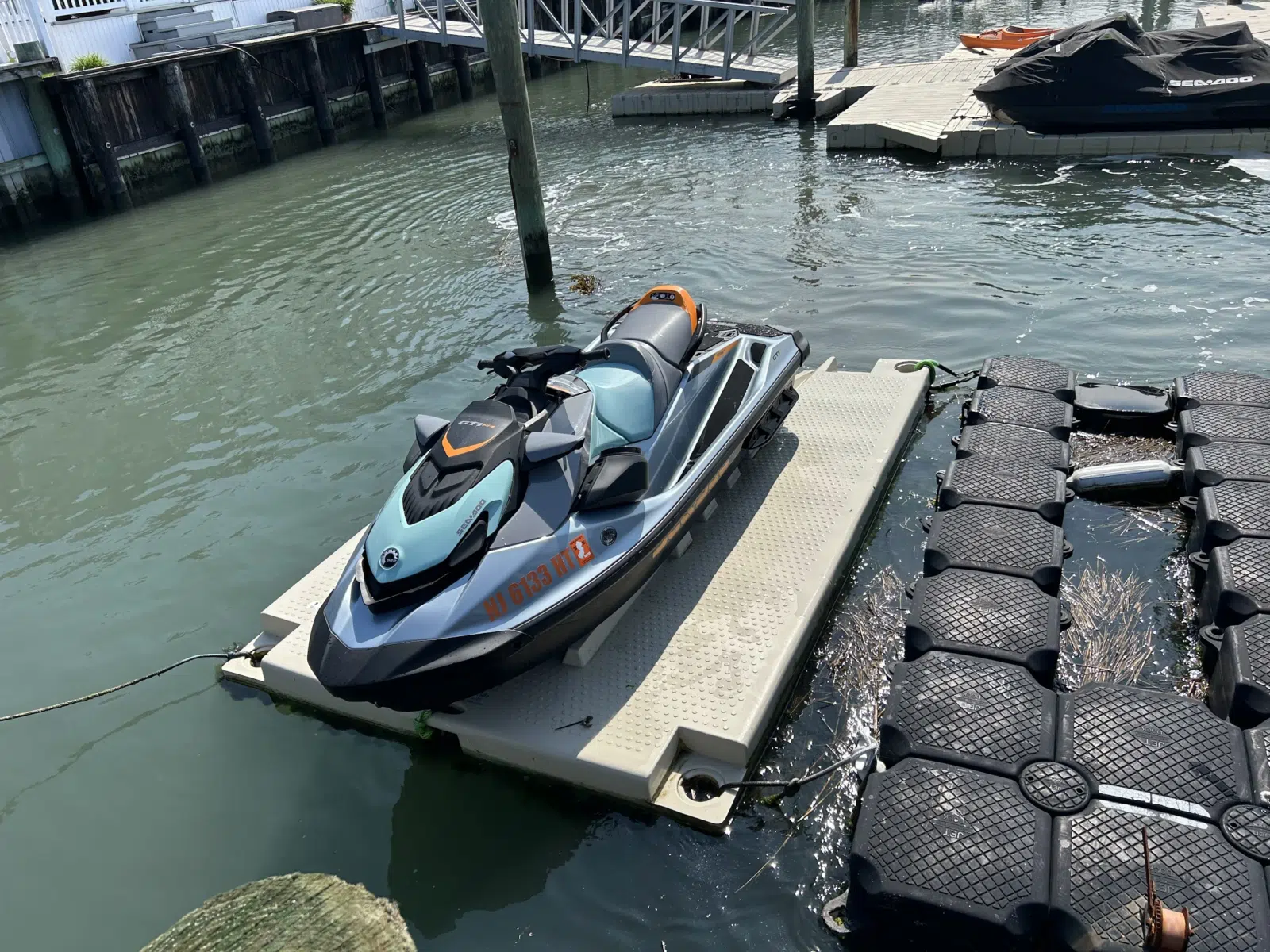 Blue jet ski docked on a floating platform at a marina — JetPro Powersport in Atlantic City